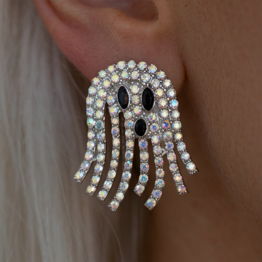 Disco Ghost Crystal earrings worn on the ear, a silver ghost with black eyes and sparkling crystal fringe