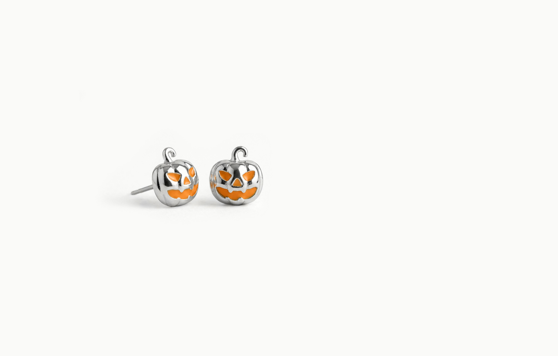 Silver jack-o'-lantern pumpkin stud earrings with an orange face