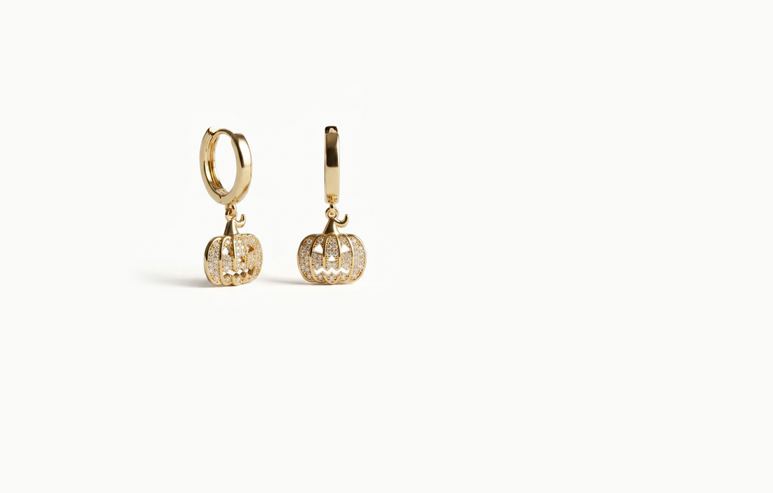 Gold drop earrings with a crystal pumpkin hanging from a small hoop