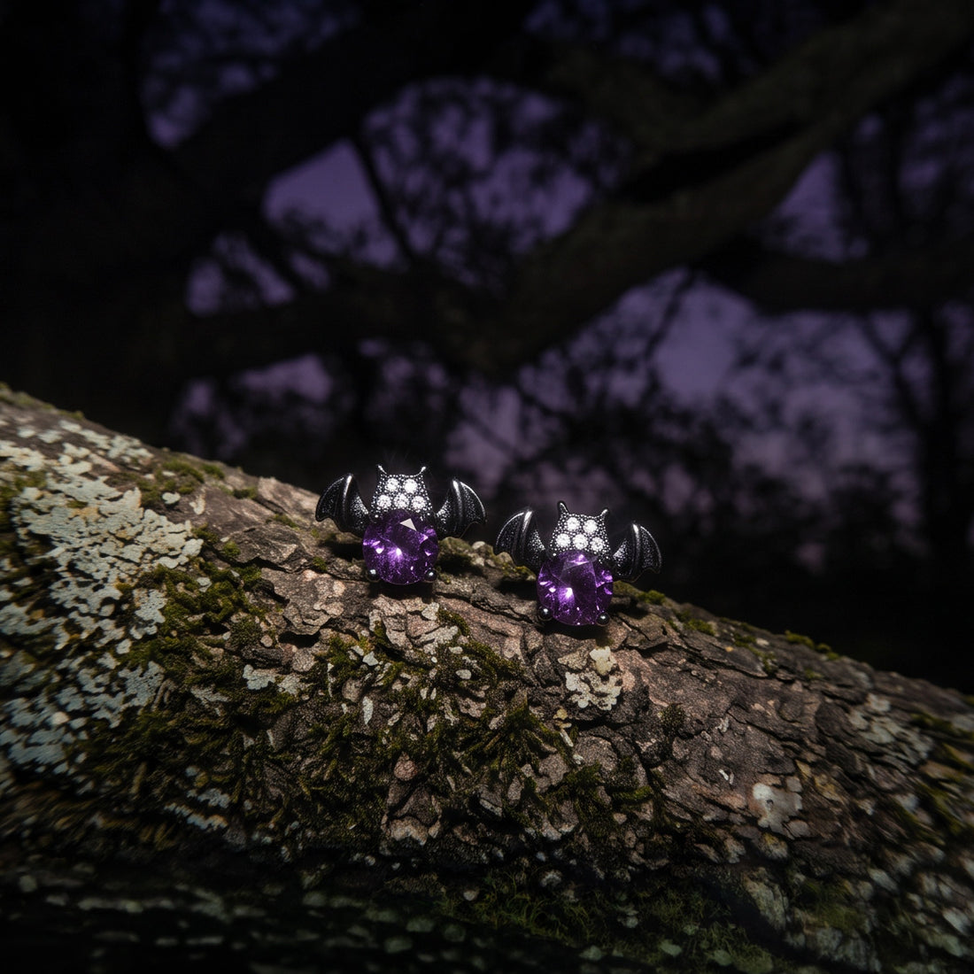 Nightshade Crystal Bat stud earrings, two dark bats with purple crystals on a mossy branch at dusk