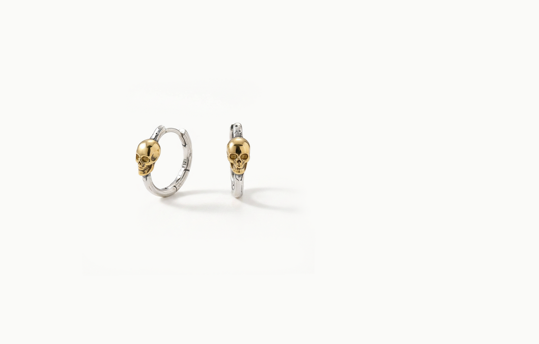 Silver hoop earrings with a gold skull