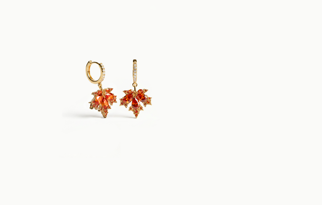 Gold drop earrings with an orange crystal maple leaf