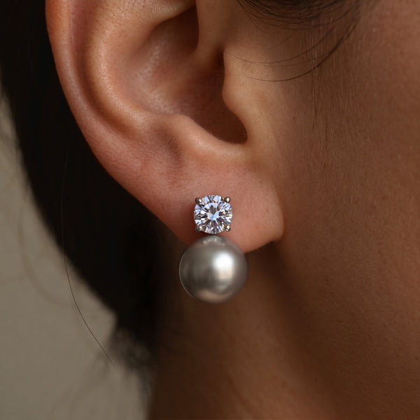 Stormy Pearl earrings worn on the ear, grey pearl hanging beneath a round crystal stud